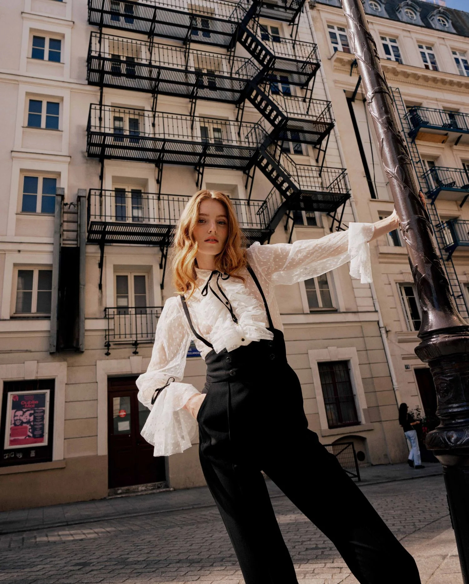 Anne Fontaine: bílá tylová halenka s volány a černou mašlí